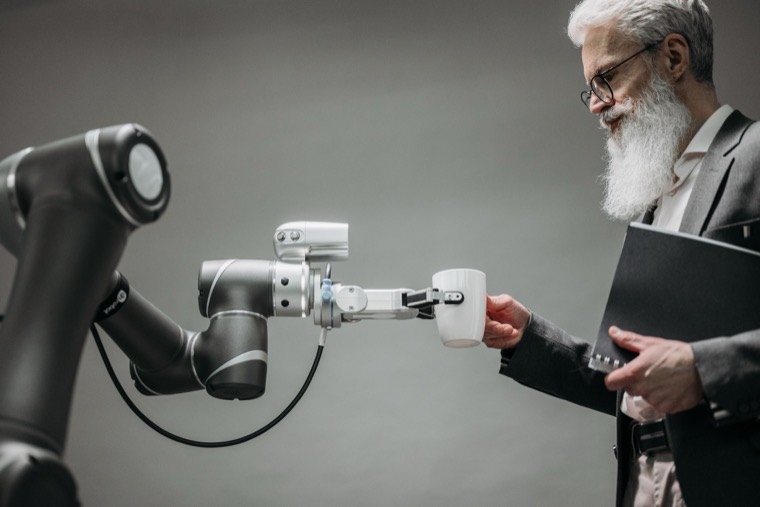 A robotic arm handing a cup to a person
